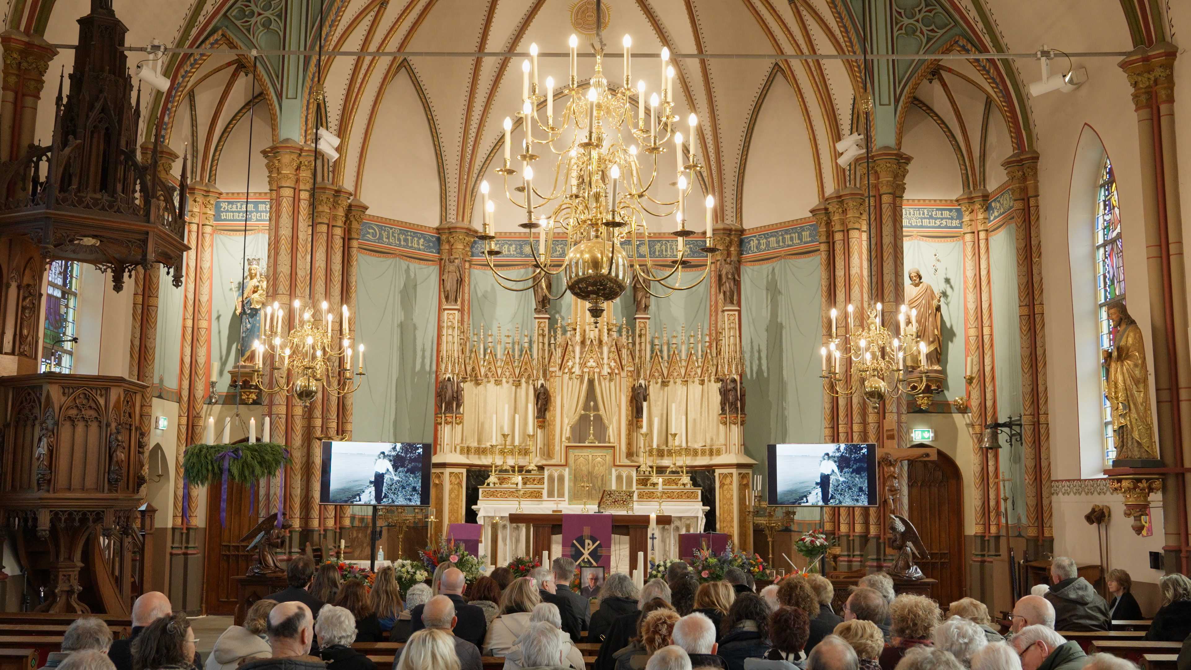 Afscheidsdienst in een kerk met aanwezigen en een uitvaartkist.